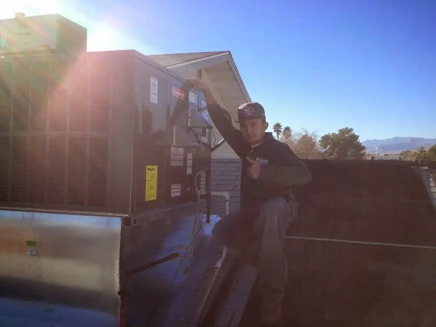 HVAC technician performing Air Duct Repair on a rooftop unit in Tallahassee